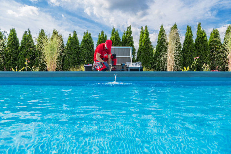 Man adding pool chemicals to in-ground swimming pool