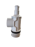 A white plastic plumbing fitting or valve component with a black rubber O-ring, standing on a brown countertop in an office setting.