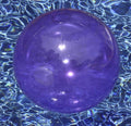Swimline Candy Transparent Beach Ball 90005 floating in a swimming pool with clear water